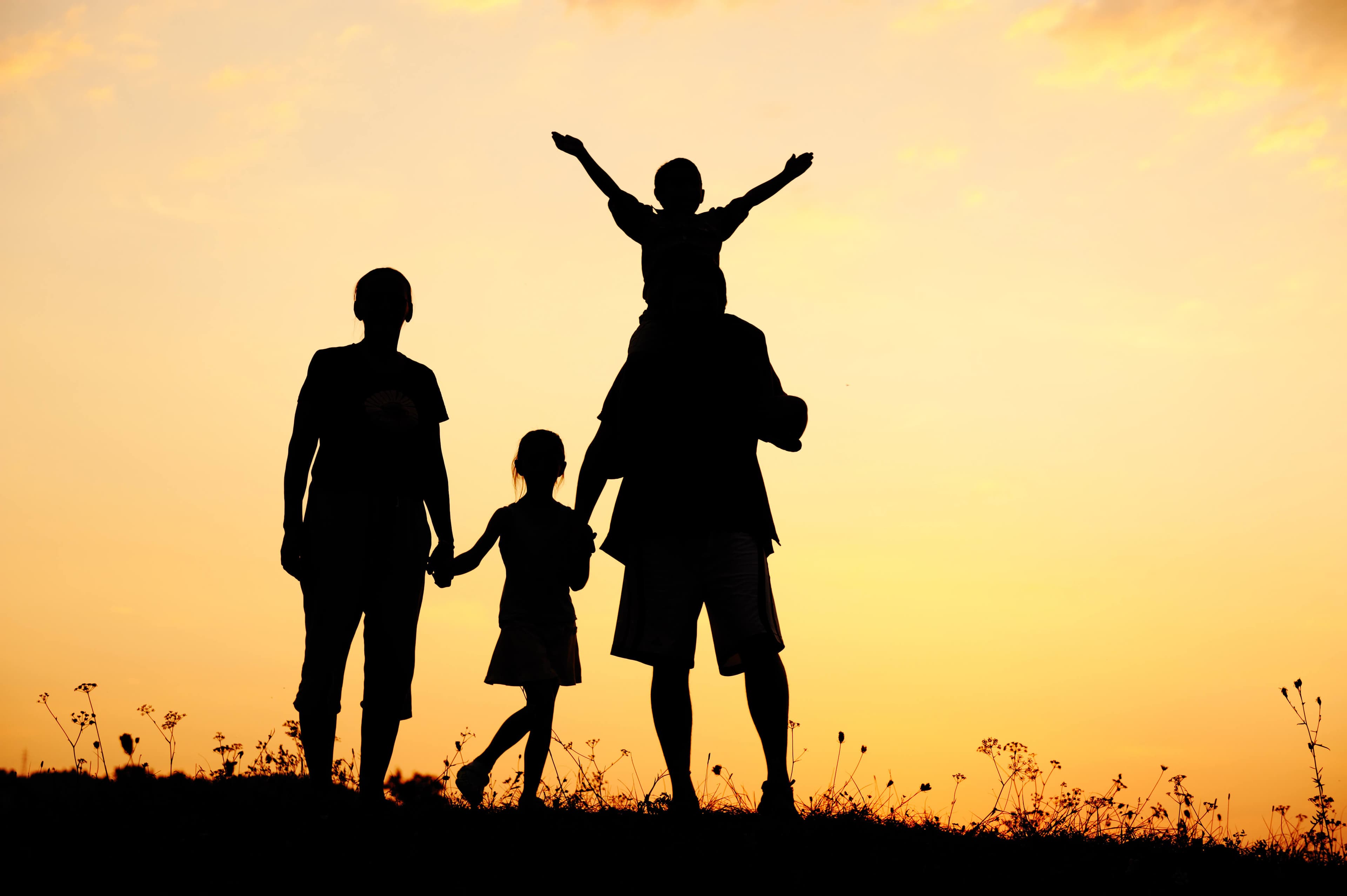 Happy family at sunset - representing financial security and peace of mind